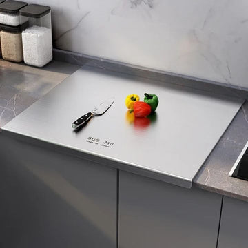 Titanium cutting board 304 stainless steel on kitchen counter with knife and bell peppers